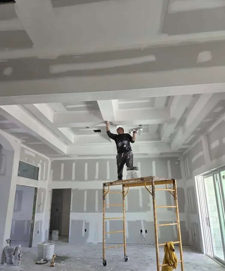 Drywall finisher at work on a coffered ceiling, drywall contractor in Lehigh Acres